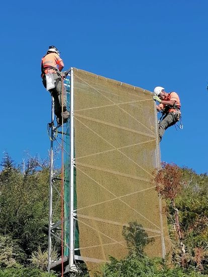 Dos operarios instalan un colector de nieblas de tipo torre en Gran Canaria. 